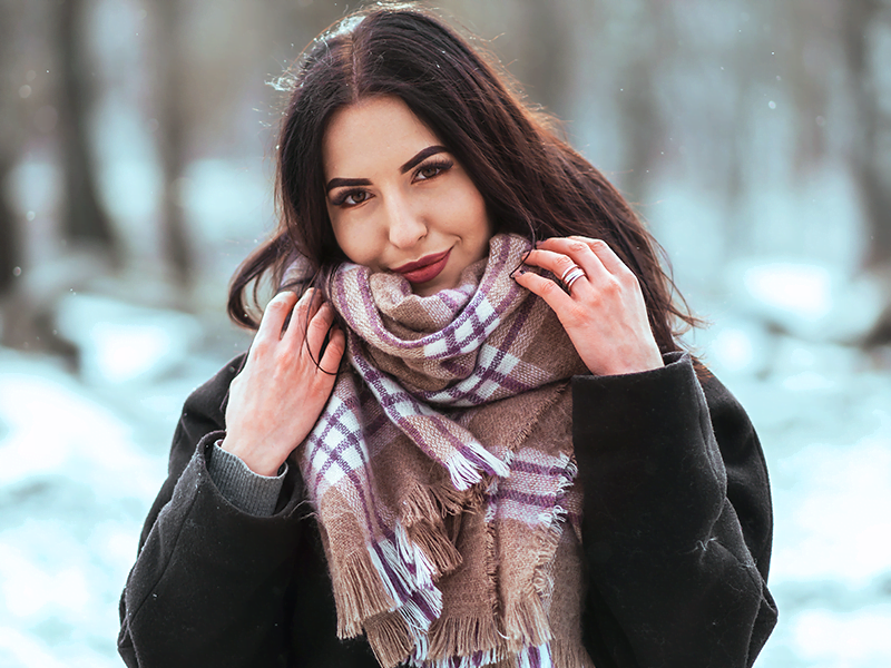 Mulher arrumando cachecol no frio