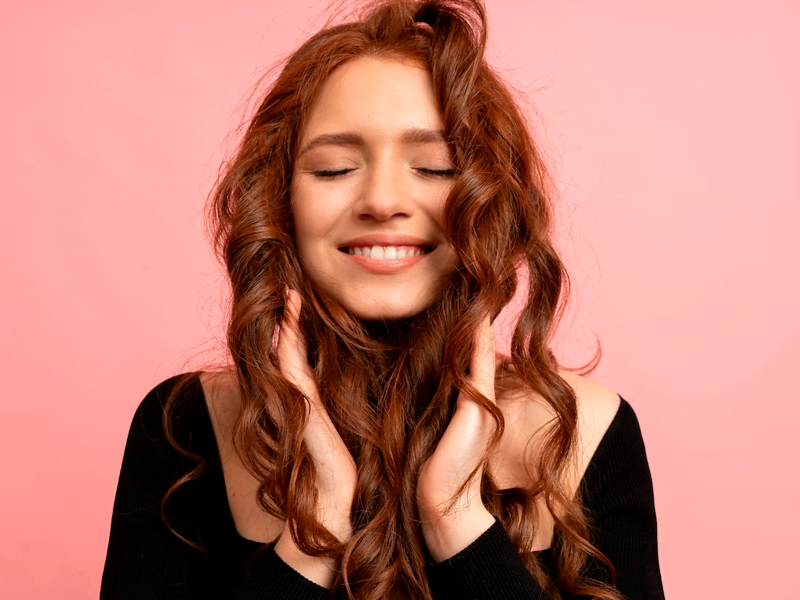 Mulher ruiva mexendo nos cabelos