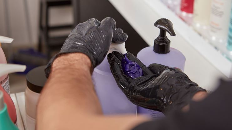 Cabeleireiro colocando cosmético na palma da mão