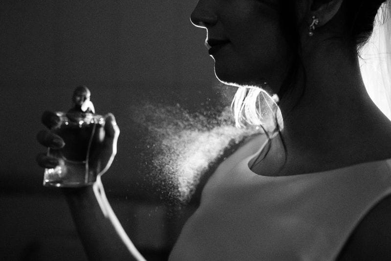 mulher aplicando perfume importado