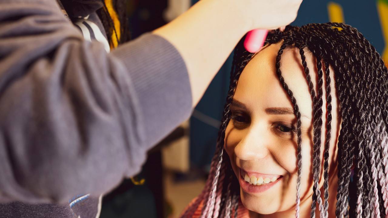 mulher ajustando as tranças