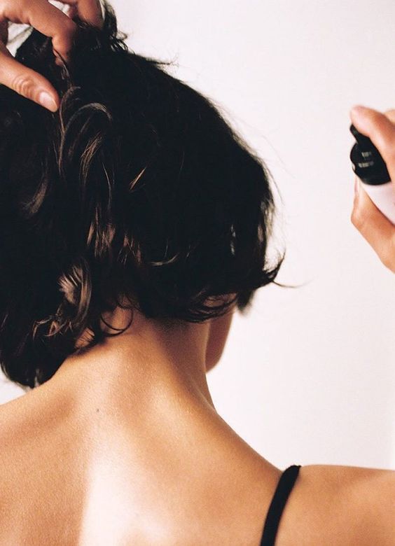 mulher passando perfume na nuca para fixar melhor