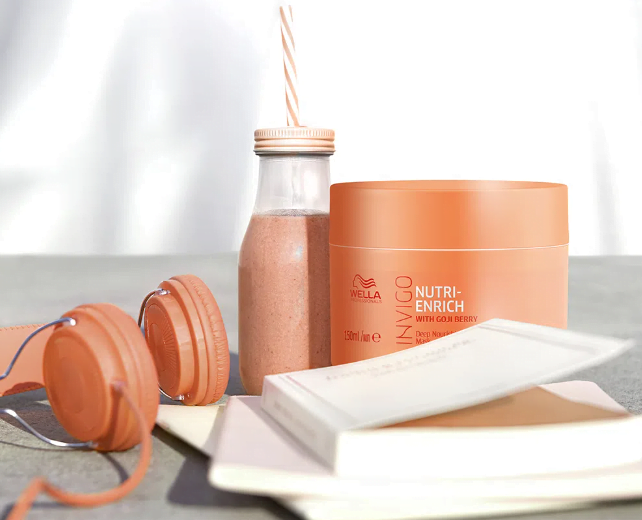 Máscara de Nutrição Wella Professionals Invigo Nutri Enrich ao lado de um livro e um fone de ouvido laranja