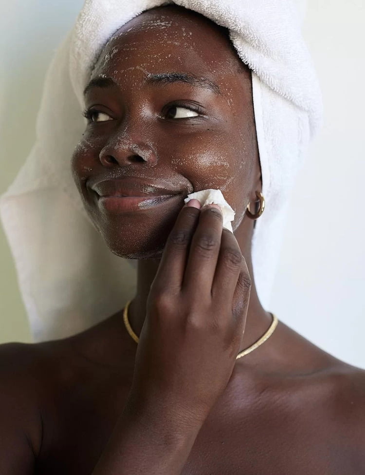 Mulher de pele negra aplicando produtos para fazer skin flooding