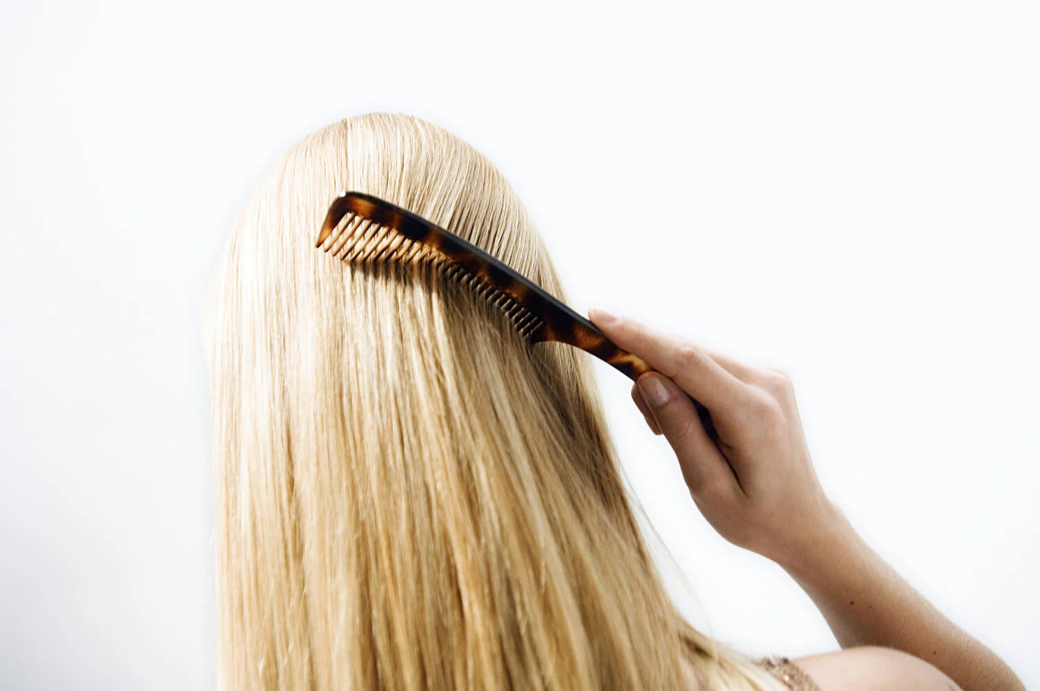 mulher passando pente em um cabelo loiro