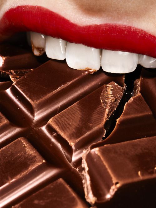 boca mordendo um pedaço de chocolate